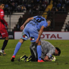 El golero Marcelo el Loco Robledo protege el esfrico tras una jugada de peligro de Deportes Iquique; abajo, los jugadores rojos saludan a su parcialidad que se traslad a territorio chileno.