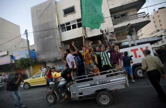 CELEBRACIN. Palestinos ondean una bandera de Hams en un vehculo durante la celebracin en las calles el alto el fuego en Gaza.