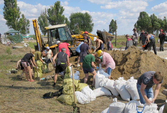 COMBATES. Voluntarios civiles excavan trincheras cerca de la ciudad de Maripol, asediada por los insurgentes afines a Rusia.