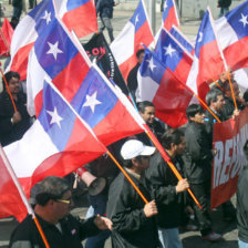 PROTESTAS. Manifestantes ondean banderas durante una marcha nacional en Chile.