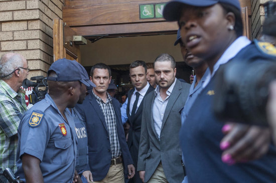 Pistorius (c) abandona el recinto donde se desarrolla el juicio.