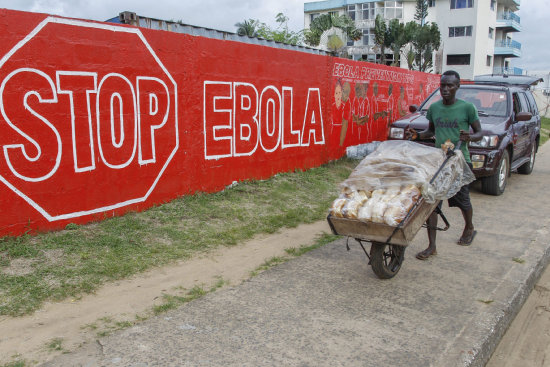 AFECTADOS. Un hombre lleva pan en una calle de Monrovia, la capital de Liberia