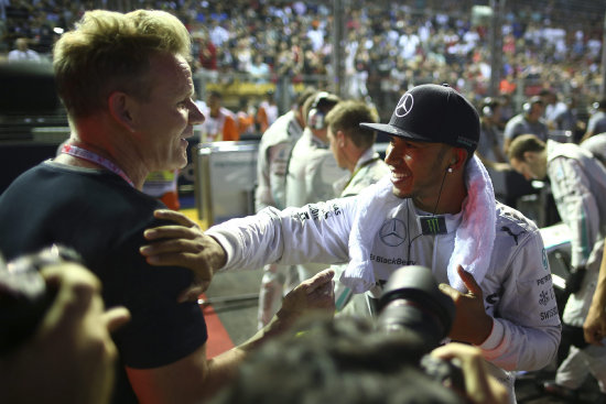 Lewis Hamilton (d) celebra su triunfo en Singapur.