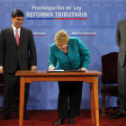 PROMULGACIN. La presidenta de Chile, Michelle Bachelet firma junto a dos de sus ministros la ley de reforma impositiva.