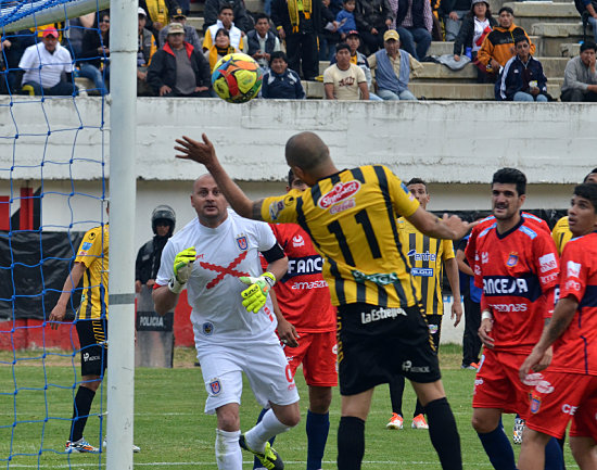 El paraguayo Ernesto Cristaldo no alcanza a cabecear la pelota hacia el arco de Universitario; al lado, Alan Loras (d) evita el ascenso de la ofensiva atigrada.