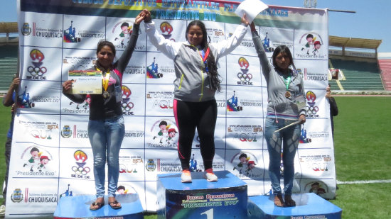 La deportista Nicol Caballero (c) celebra en el podio luego de ganar la medalla de oro en la especialidad de lanzamiento de disco, durante la ltima jornada de la disciplina de atletismo.