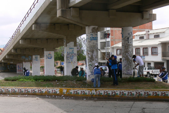 LIMPIEZA. Militantes del MAS quitan la propaganda electoral cerca al colegio Serrano.