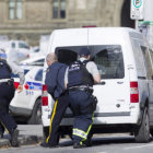 ATAQUE. Policas canadienses se cubren tras un vehculo durante el tiroteo protagonizado por un individuo cerca del Parlamento en Ottawa.