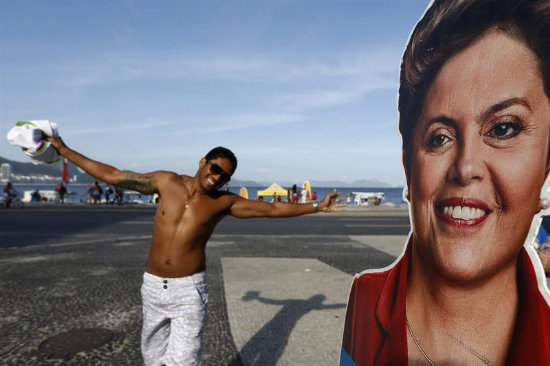 PROPAGANDA. Un hombre posa frente a una propaganda con la imagen de la presidenta de Brasil y candidata a la reeleccin Dilma Rousseff.