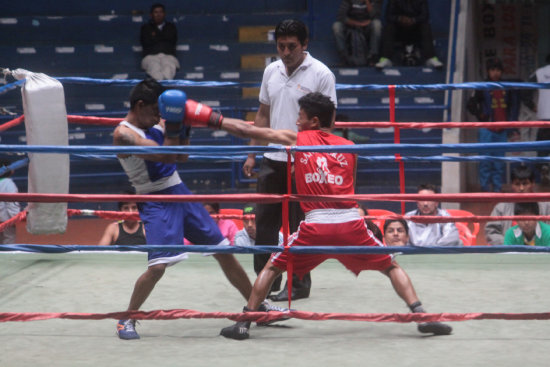 Un pasaje del combate entre el cruceo Jorge Luis Paz (rojo) y el potosino Jos Ariel; abajo, la chuquisaquea Edith Maturano (azul) fue proclamada ganadora del combate por abandono.