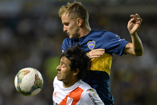 Colazo (arriba) de Boca disputa la pelota a Pisculichi de River Plate.