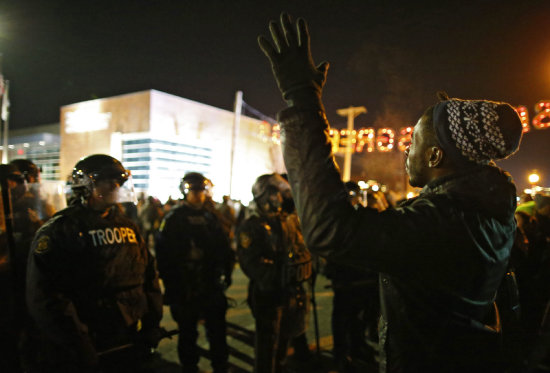 DISTURBIOS. Un manifestante negro desafa a la Polica durante los disturbios en Ferguson.