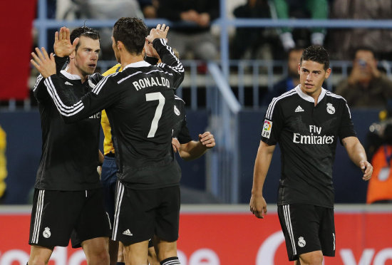 El jugador gals Gareth Bale (i) es felicitado por Cristiano Ronaldo (c) tras marcar el segundo gol ante el Mlaga, durante el partido de ayer.