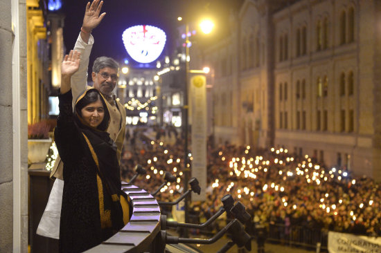 DESFILE. La pakistan Malala Yousafzai (i) y el indio Kailash Satyarthi (d) saludan desde el balcn del Grand Hotel durante el desfile con antorchas.