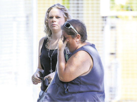 CRIMEN. Una mujer llora frente a la vivienda donde fueron encontrados los menores.