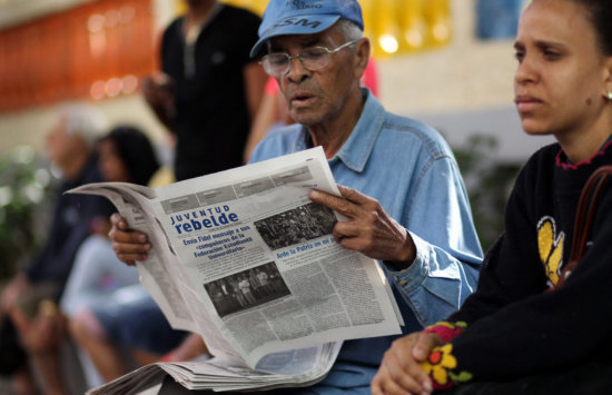 OPININ. Ciudadanos cubanos leen la prensa luego del mensaje de Fidel Castro.