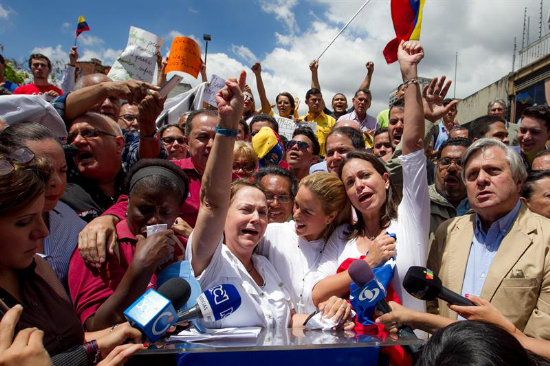 PROTESTA. La esposa del alcalde detenido, Mitzy Capriles (i), participa de una marcha.