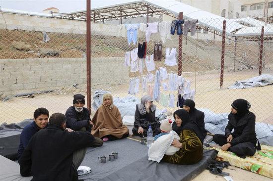 CONFLICTO. Familias sirias evacuadas por el Ejrcito del rea rebelde de Douma descansan en un centro de acogida temporal.