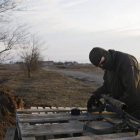 CALMA. Un miembro de las fuerzas ucranianas prepara su rifle mientras hace guardia en la localidad de Shyrokino, cerca de Mariupol.